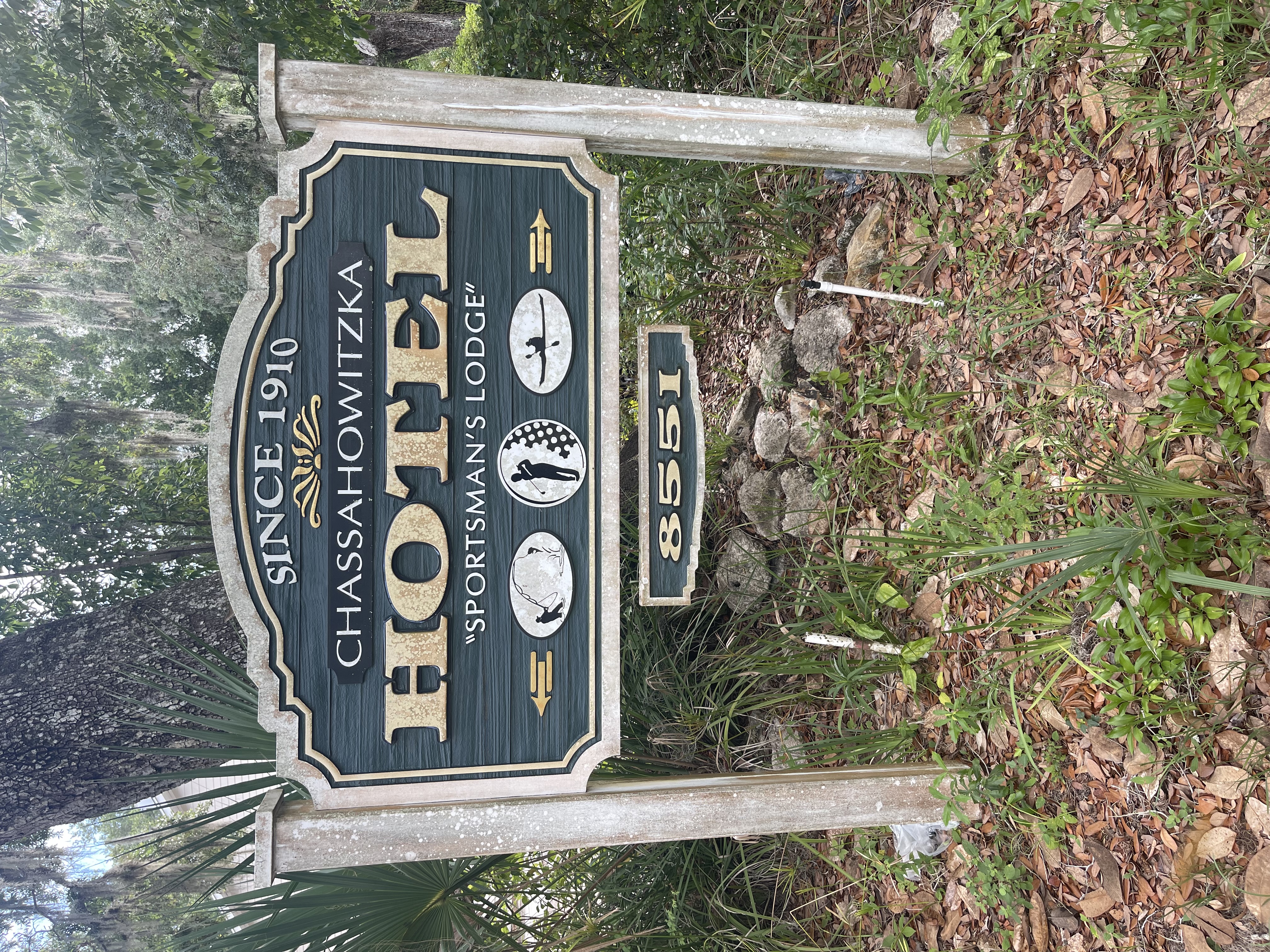 Historic Chassahowitzka Hotel Sportsman's Lodge sign beneath moss-draped trees